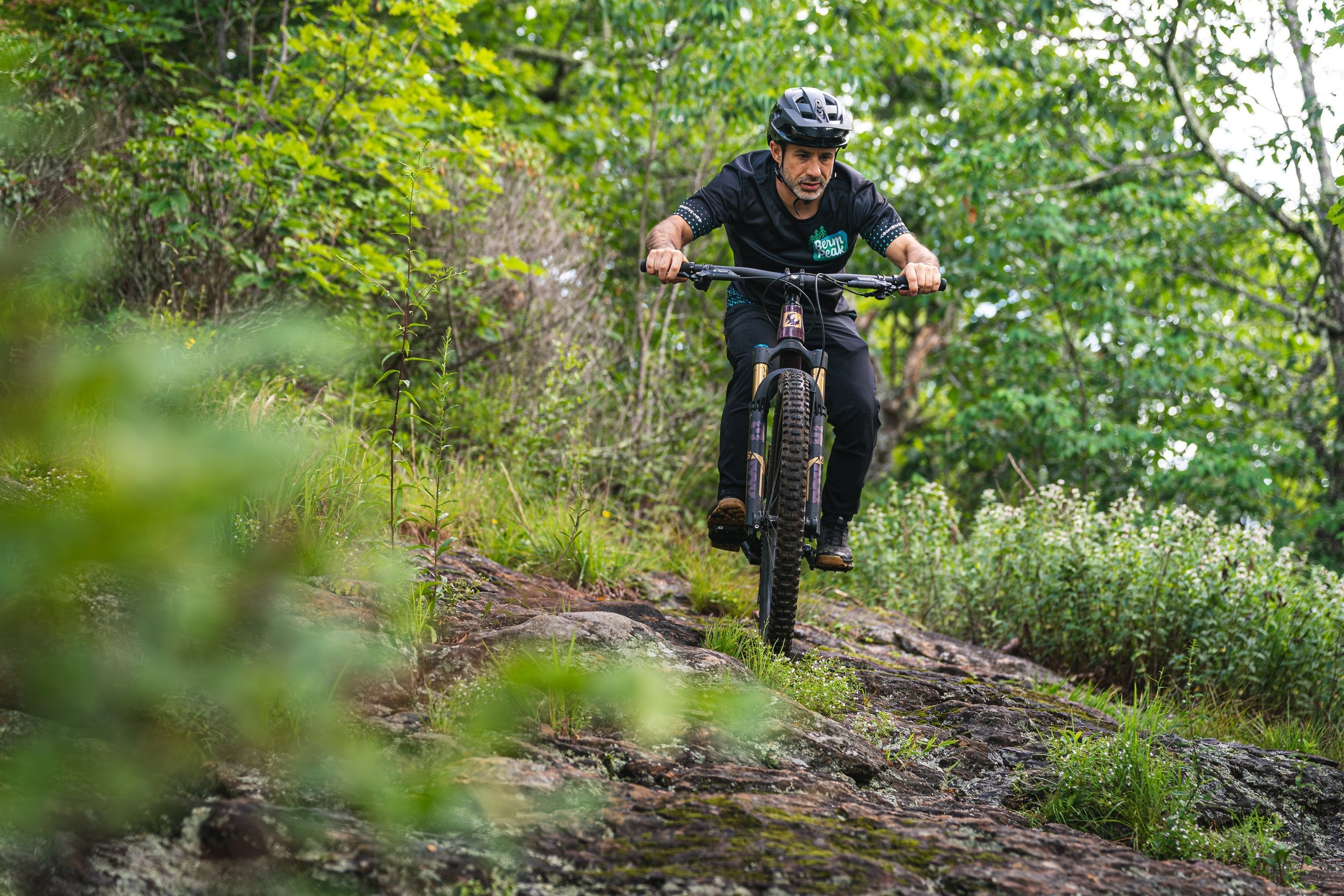 Seth Alvo riding a mountain bike trail in Berm Peak gear