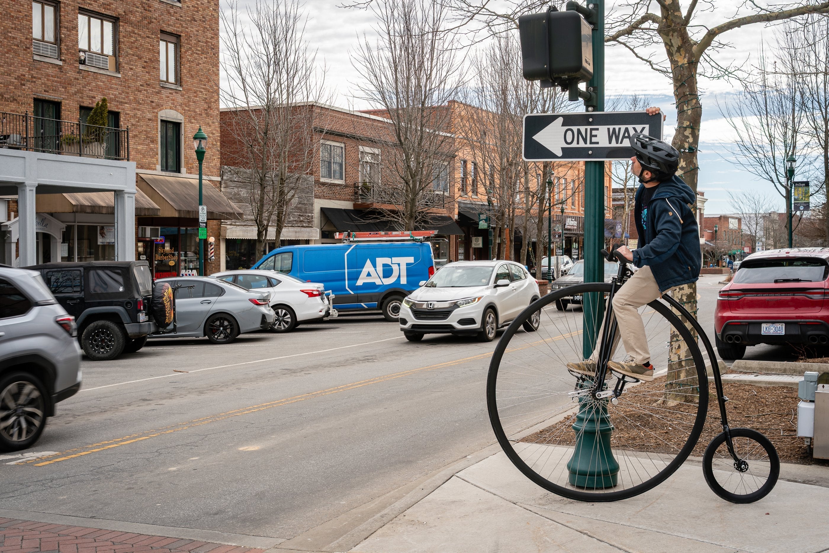 Seth Alvo riding a penny-farthing through downtown Hendersonville