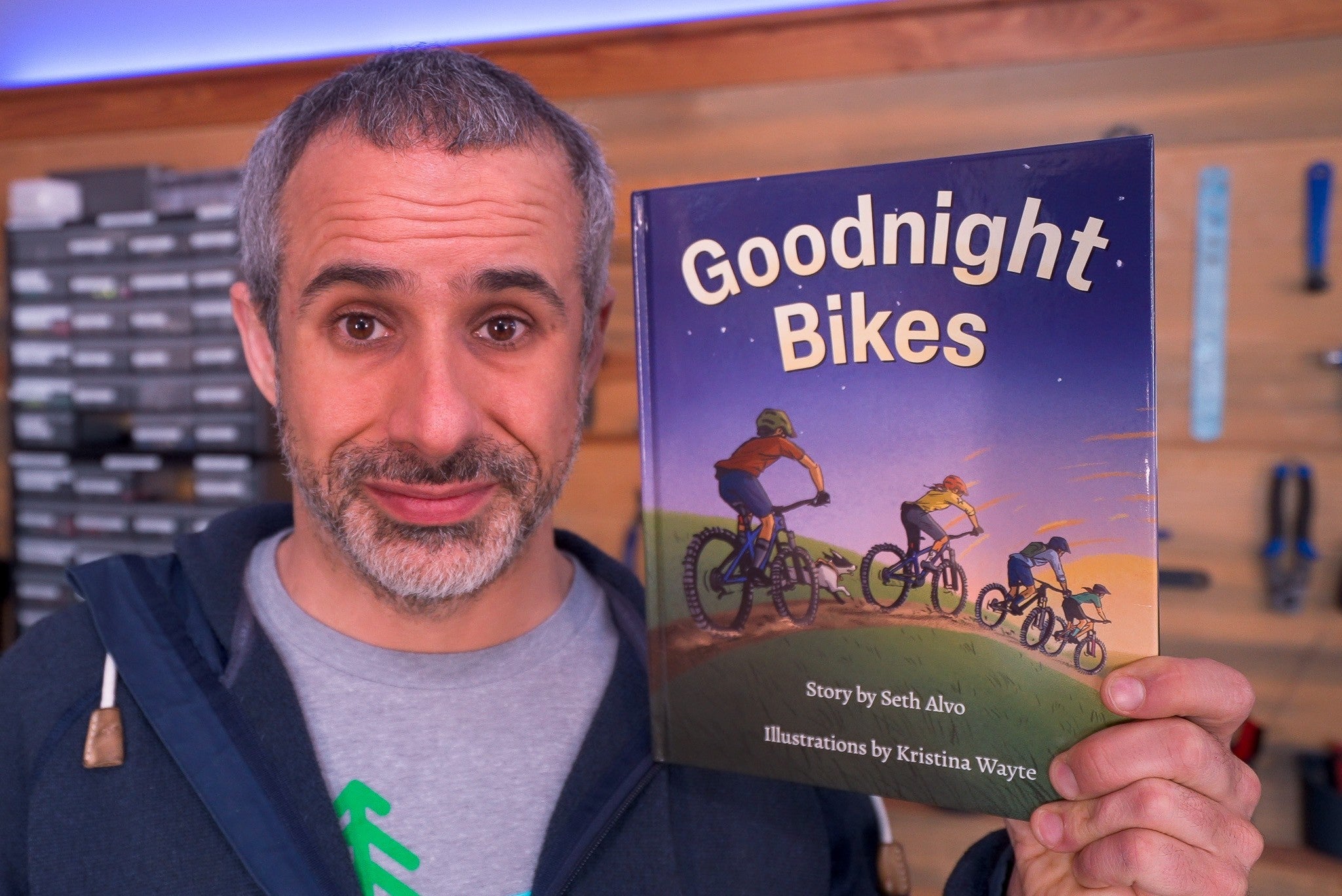 Seth Alvo of Berm Peak holding the Goodnight Bikes hardcover book he wrote